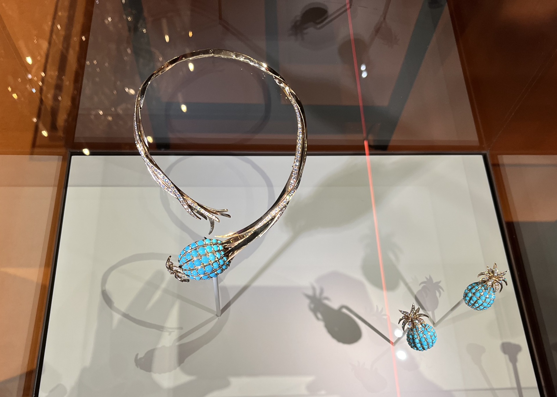 collier et paire de boucles d'oreilles ananas en or jaune, turquoise et diamants, de la collection Mahnaz. Les bijoux semblent raconter une histoire, évoquer des émotions, souvenirs associés à des fleurs ou destinations lointaines